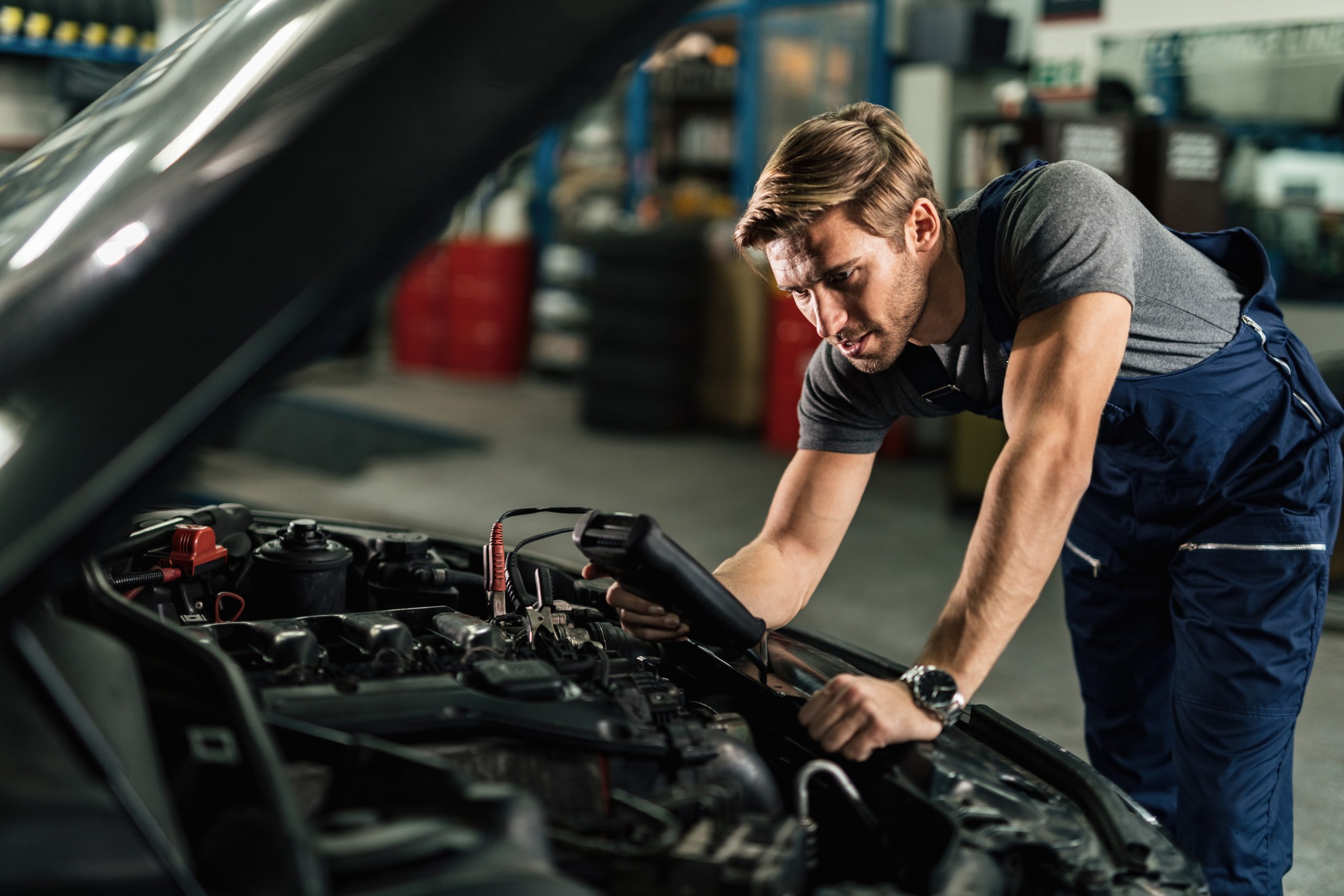 Profissional trabalha no sistema elétrico de um carro