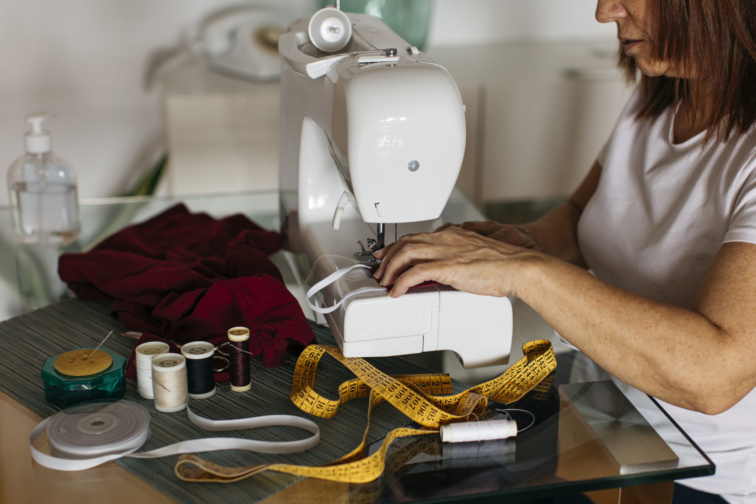 Costureira costura elástico em peça de roupa com maquina de costura